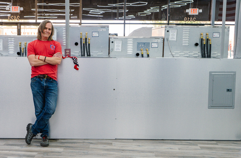 Freedom Bulkheads founder stands leaning against a customer bulkhead.